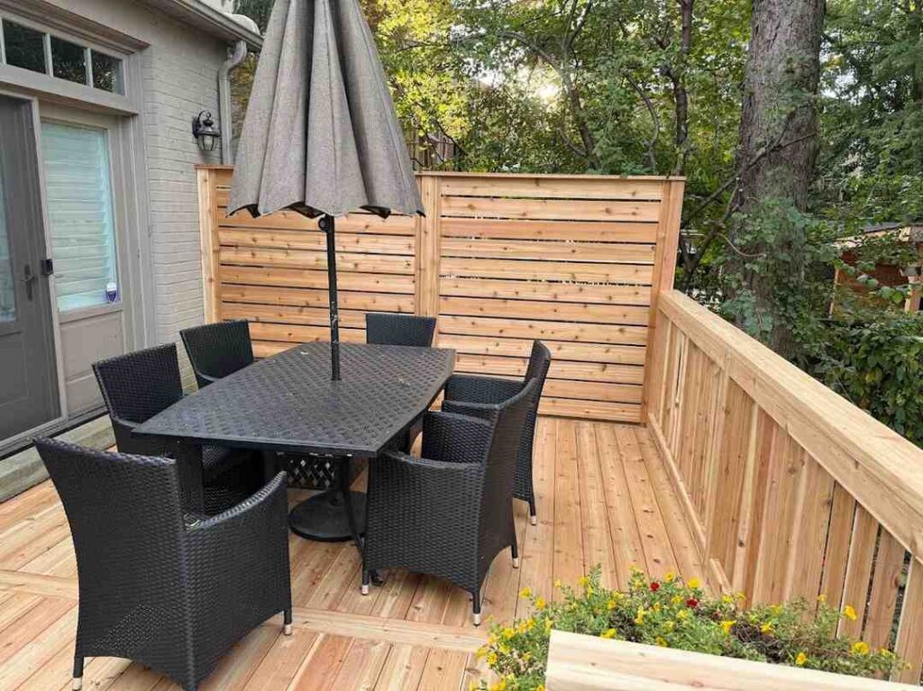 A cedar deck with built in privacy screen and custom railings in North Toronto.