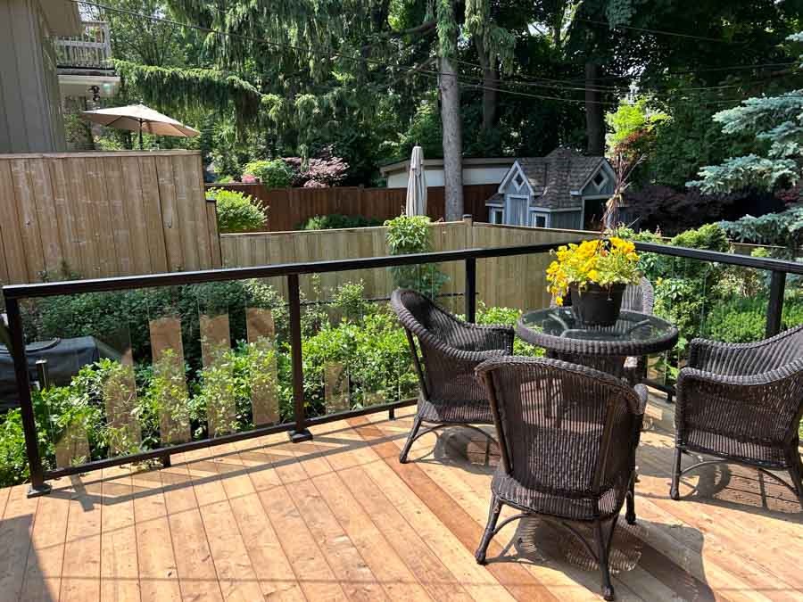 back deck with nice table and chairs set, glass railings by Kerta Construction