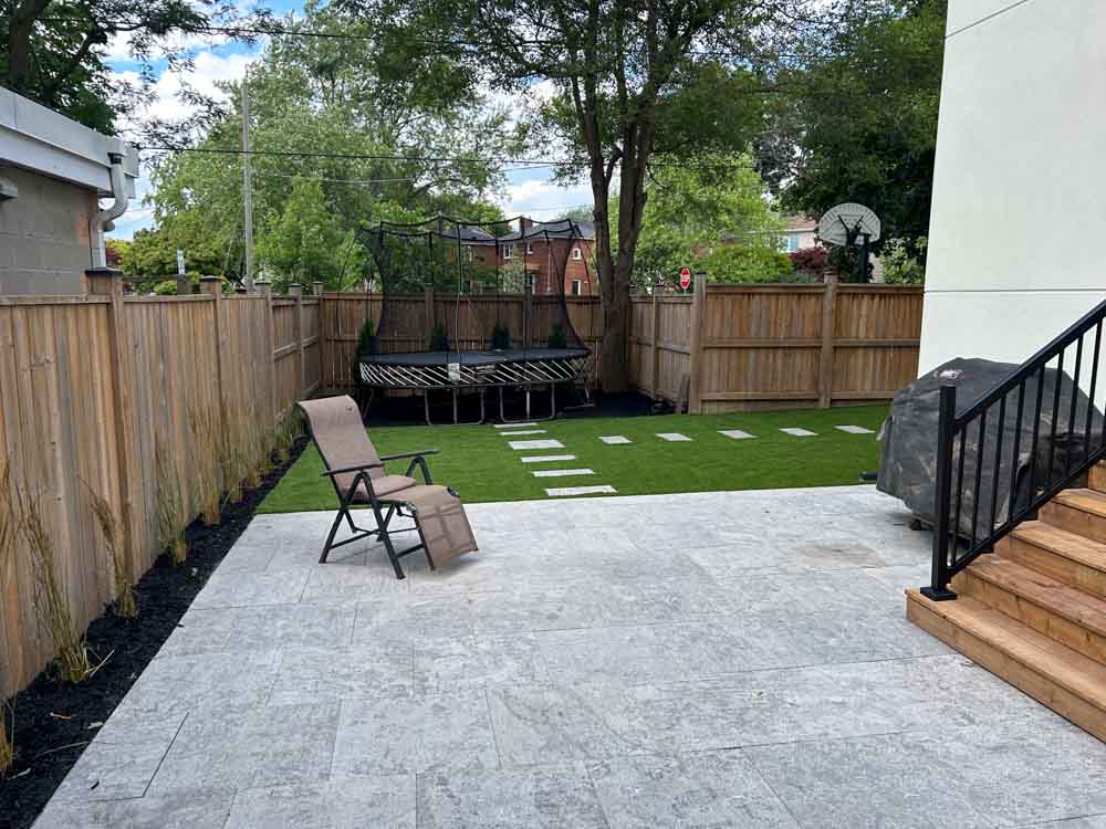 Hardscaping-img1 back yard with paver stones, fence and custom steps