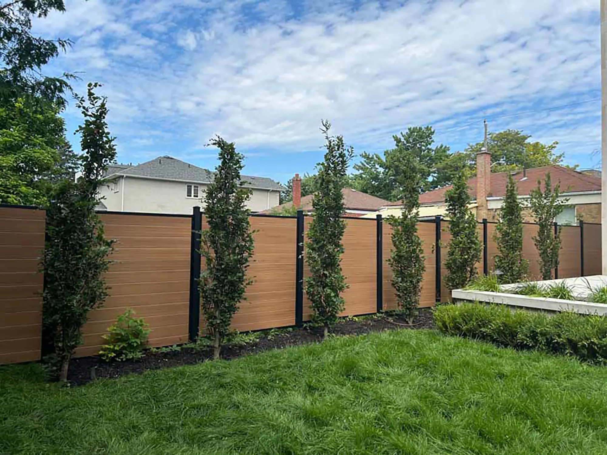 Home-hero back yard with holly tress and nice landscaping by Kerta Construction