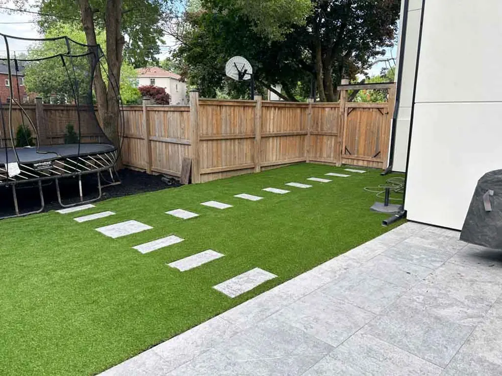 back yard with trampoline and patio by Kerta Construction