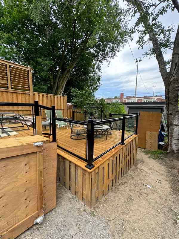 multi tiered back deck with glass railings by Kerta Construction