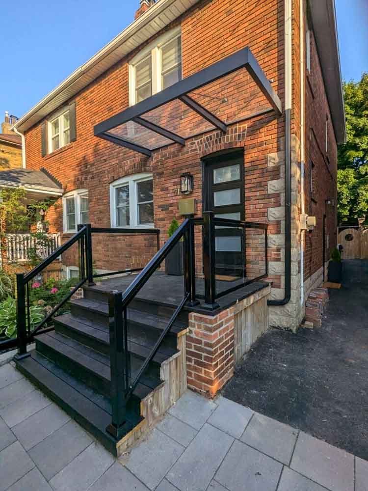 Outdoor-living-img1 front door with black steps and glass railings by Kerta Construction