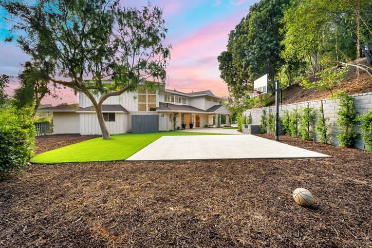 Modern backyard renovation with lawn, sports court, and landscaping in Toronto, ON