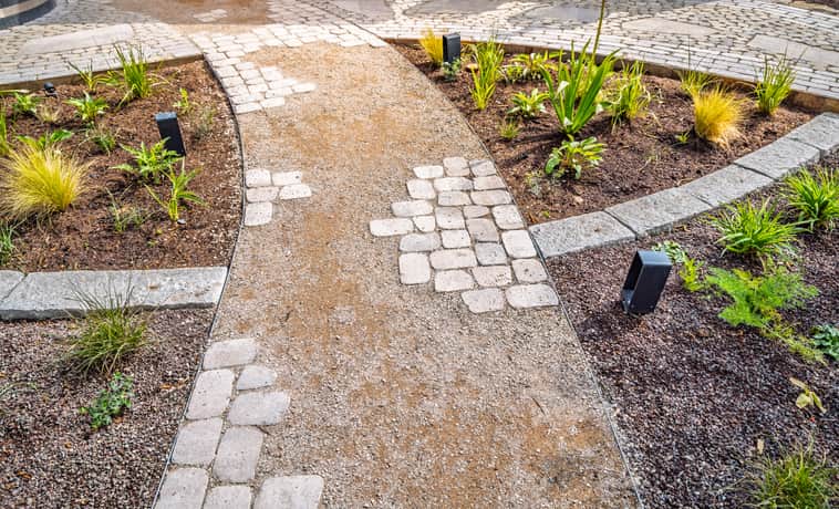 Paver and gravel walkway showcasing materials for patio design in Toronto, ON